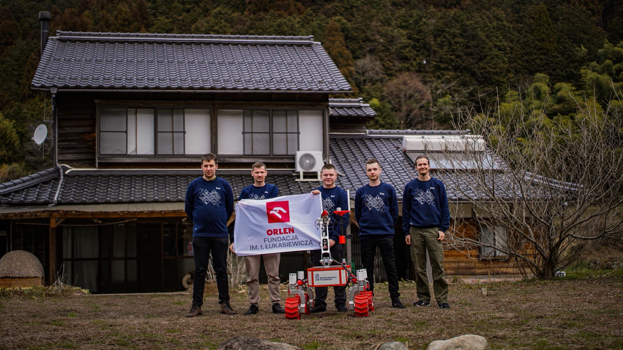 Rover team, at the background house and forest